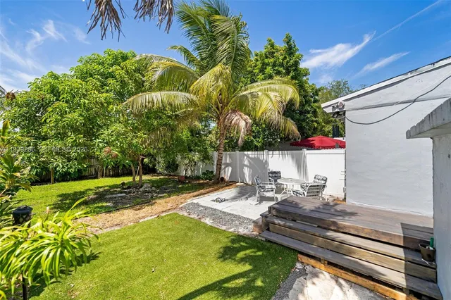 a view of a backyard with plants and a patio