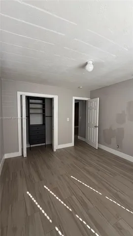 a view of an empty room with closet and fire place
