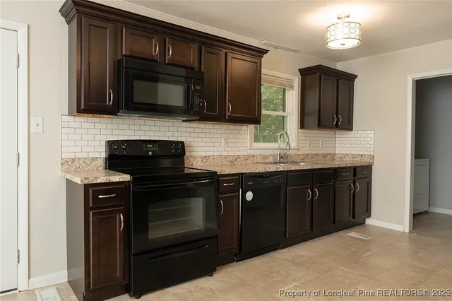 a kitchen with stainless steel appliances a stove microwave and sink