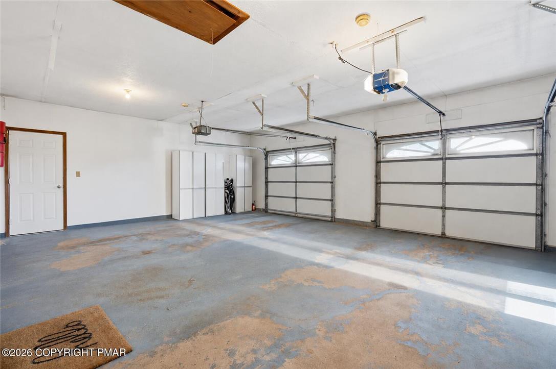 123 Meadow Road Blakeslee, PA 18610 - Photo 35 of 53 A spacious garage includes built-in storage cabinets alongside overhead access to attic space.