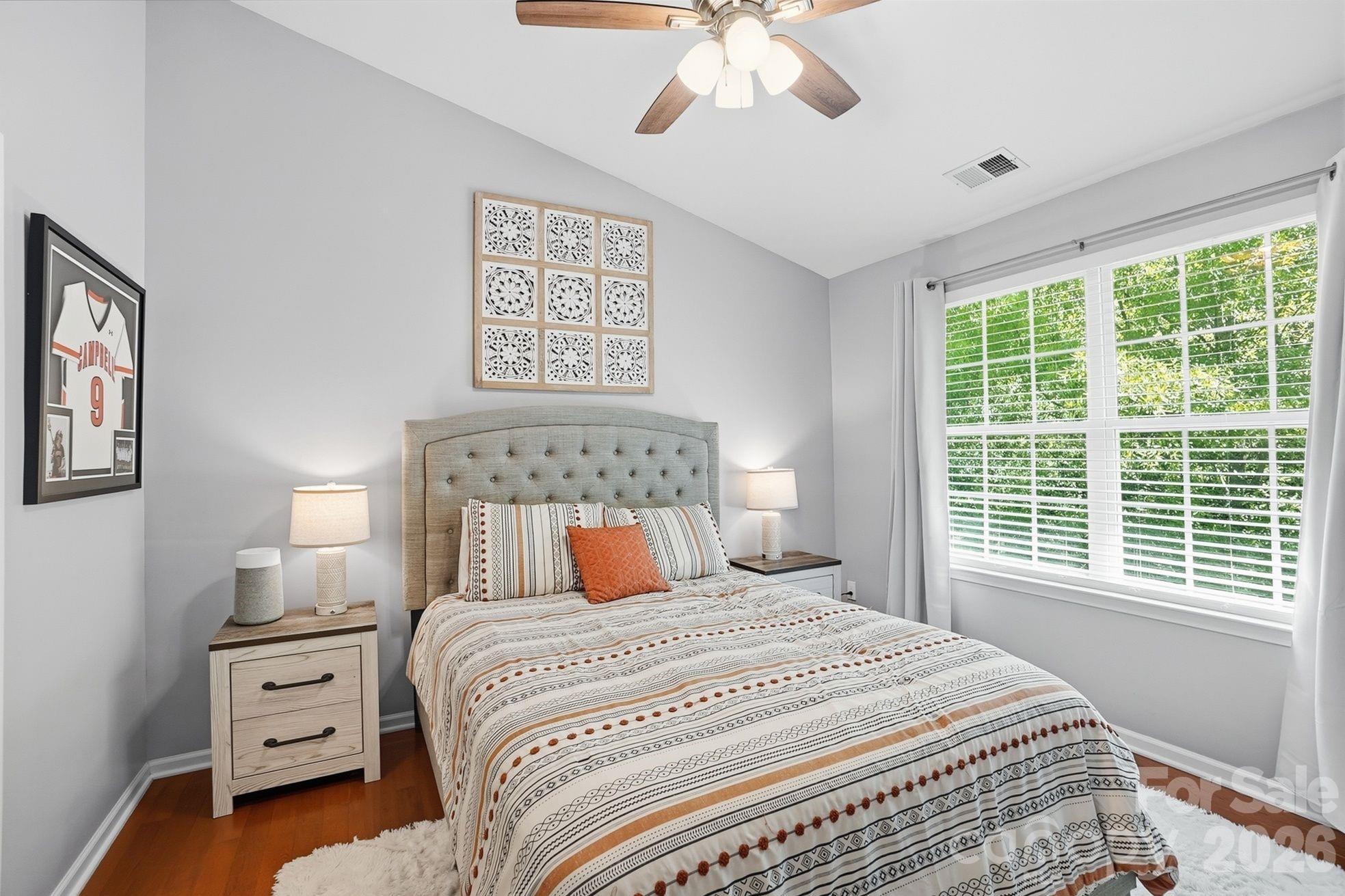 8512 Sunset Hill Road Waxhaw, NC 28173 - Photo 13 of 36 a bedroom with a large bed and a chandelier