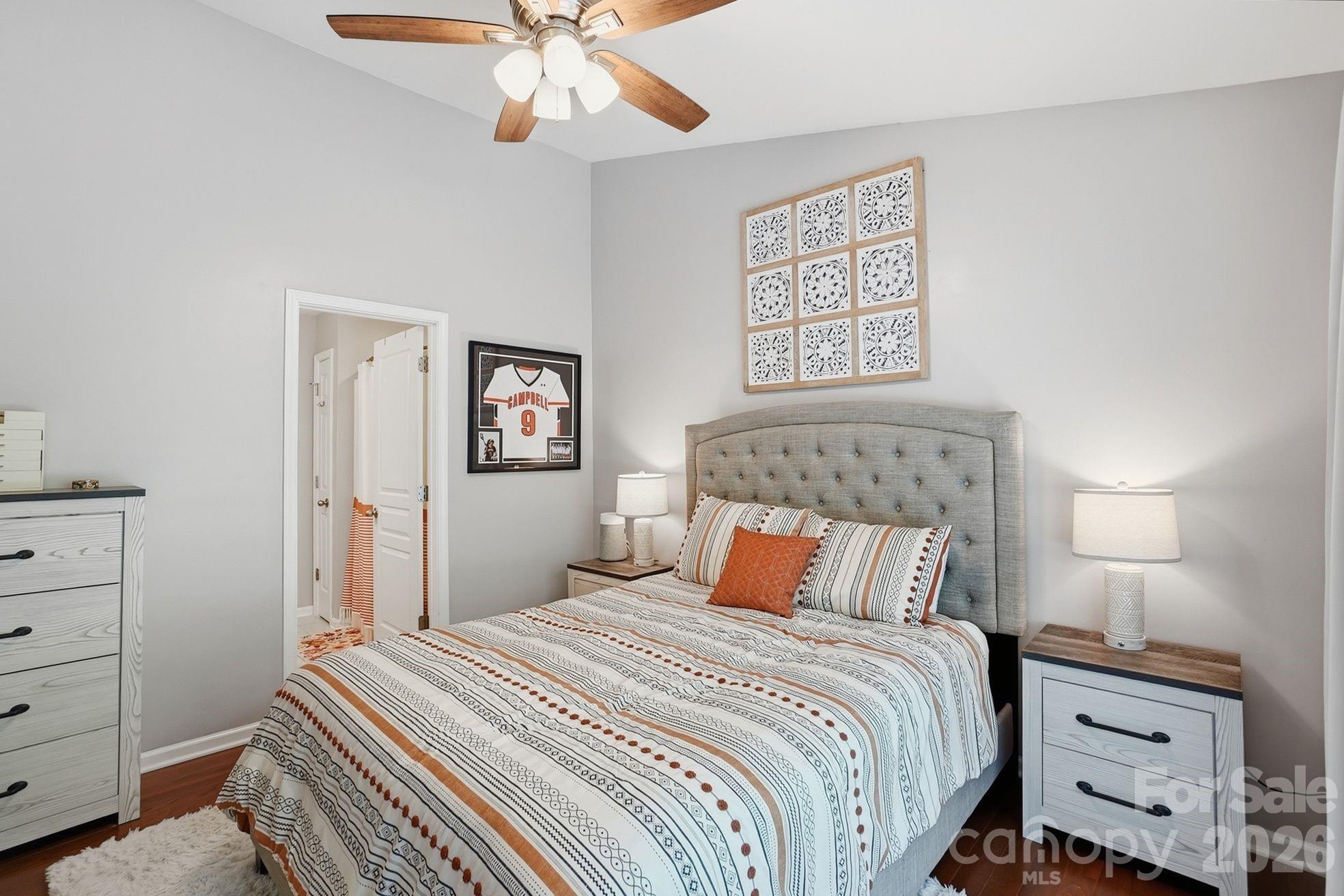 8512 Sunset Hill Road Waxhaw, NC 28173 - Photo 14 of 36 a bedroom with a large bed and a chandelier