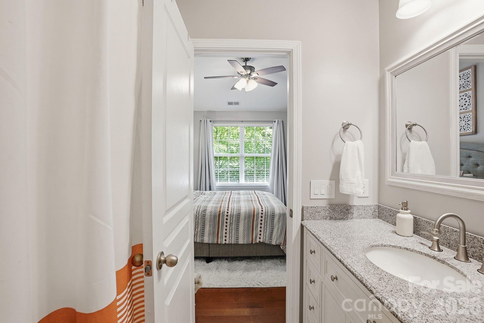 8512 Sunset Hill Road Waxhaw, NC 28173 - Photo 21 of 36 a en suite bathroom with a granite countertop sink a mirror and a bathtub