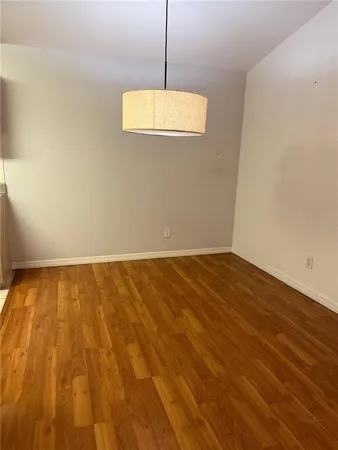 a view of a room with wooden floor and a ceiling fan