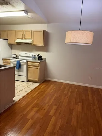 a kitchen with granite countertop a stove a sink and a microwave