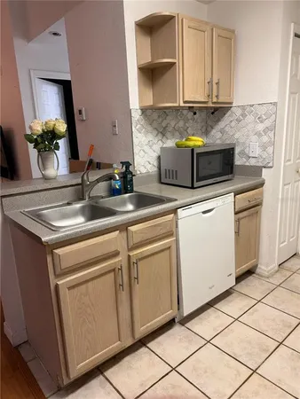 a kitchen with granite countertop a sink white cabinets and a stove