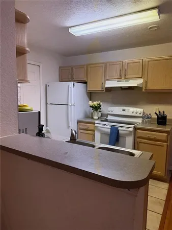 a kitchen with kitchen island a sink a stove and refrigerator