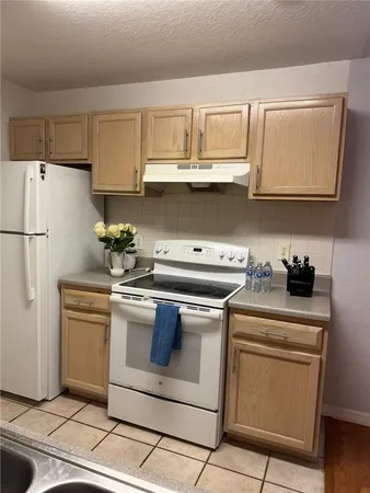 a kitchen with granite countertop white cabinets and white appliances