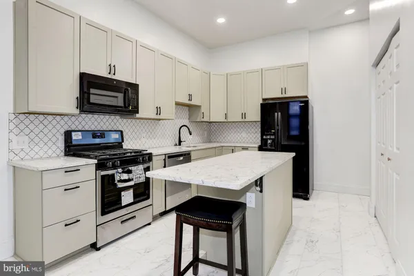 a kitchen with stainless steel appliances a stove microwave and refrigerator
