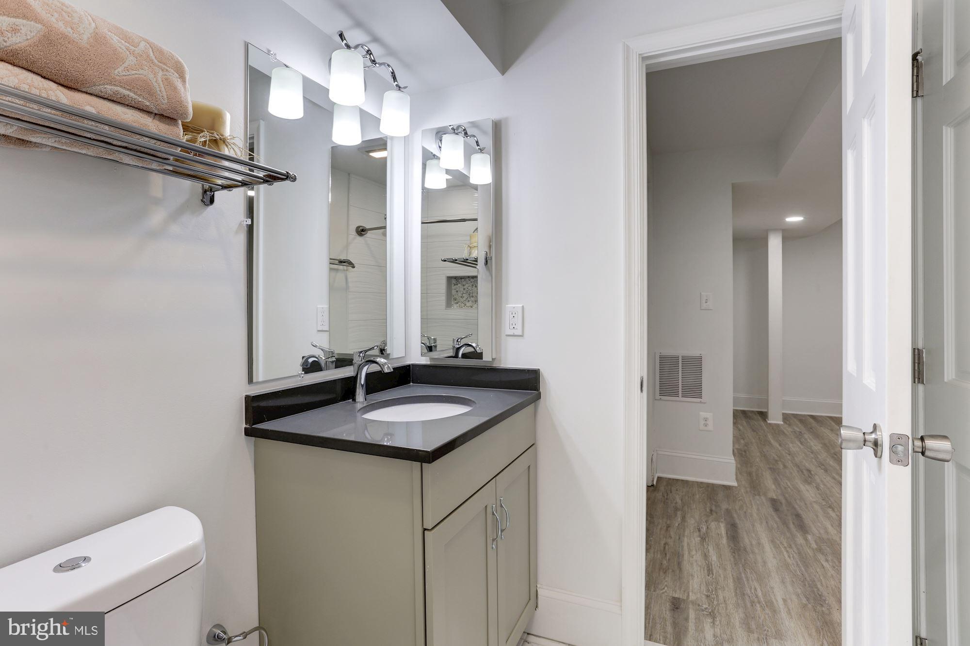 638 G Street Northeast Washington, DC 20002 - Photo 12 of 25 a bathroom with a granite countertop sink a toilet and a mirror