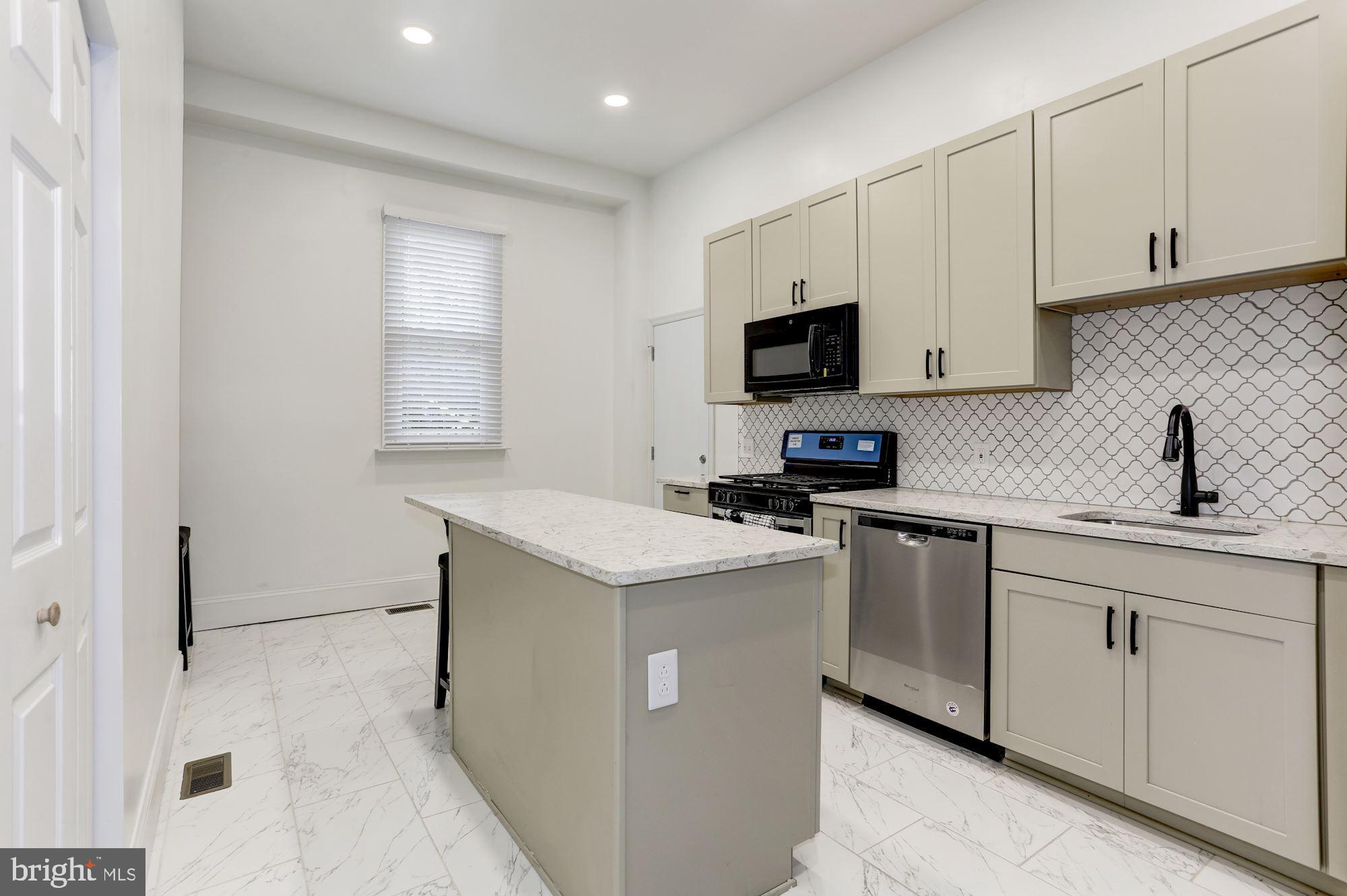 638 G Street Northeast Washington, DC 20002 - Photo 3 of 25 a kitchen with granite countertop white cabinets and stainless steel appliances