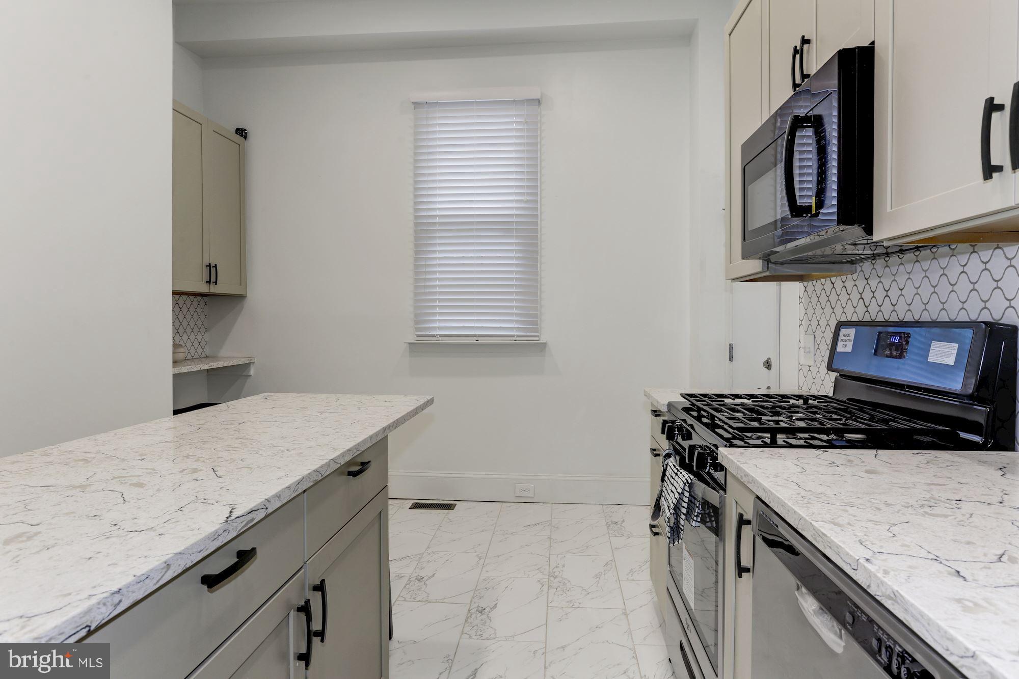 638 G Street Northeast Washington, DC 20002 - Photo 5 of 25 a kitchen with granite countertop a stove and a sink
