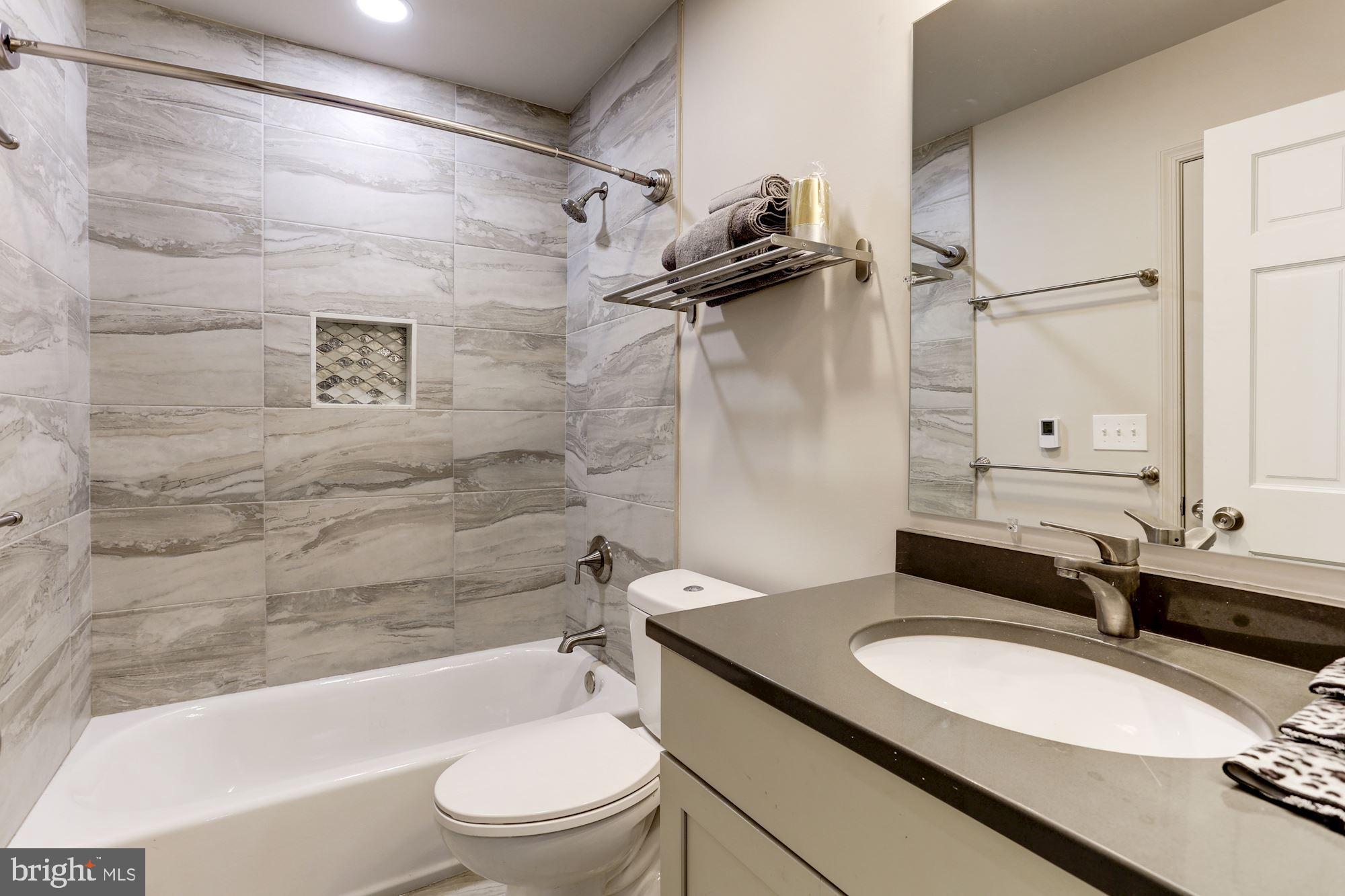 638 G Street Northeast Washington, DC 20002 - Photo 9 of 25 a bathroom with a granite countertop sink toilet a mirror and shower