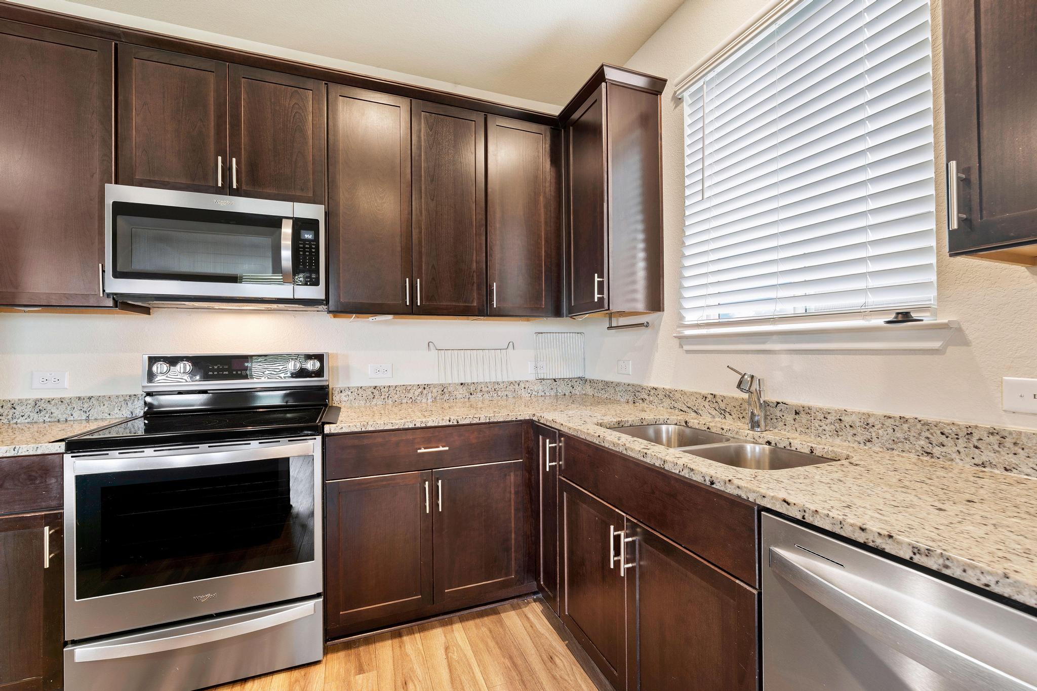 217 Innisfree Road Jarrell, TX 76537 - Photo 14 of 39 A well-appointed culinary space featuring ample dark wood cabinetry and pristine granite countertops.