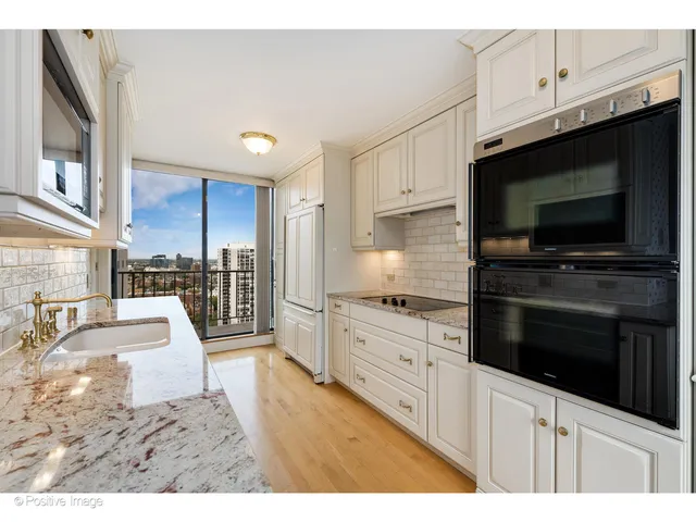 a kitchen with stainless steel appliances kitchen island granite countertop a stove microwave and cabinets