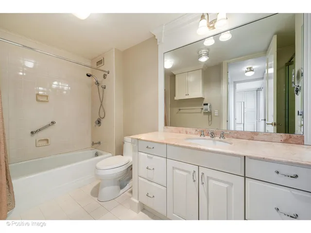 a bathroom with a double vanity sink toilet mirror and shower