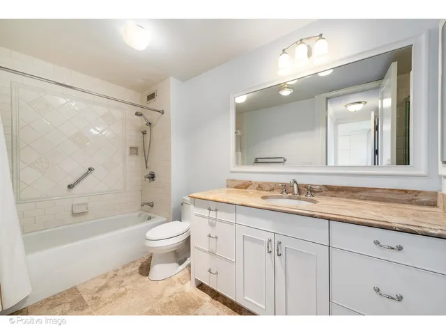 a bathroom with a granite countertop toilet a sink and a bathtub