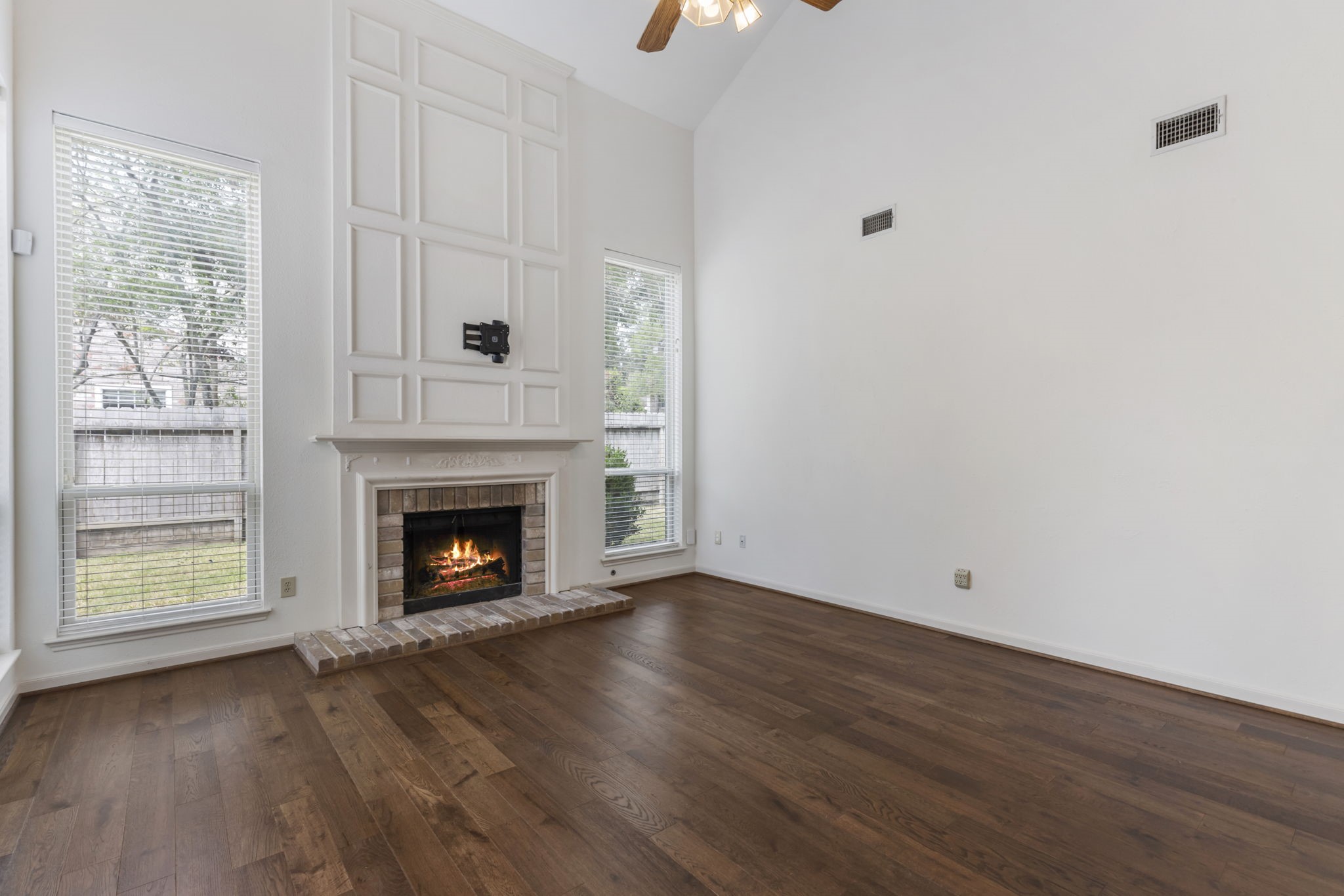 59 Fire Flicker Place Spring, TX 77381 - Photo 13 of 37 Experience the perfect blend of warmth and elegance in this bright living room, high ceilings, wood flooring, a cozy fireplace, and large windows that flood the space with natural light.