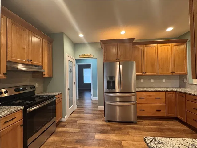 a kitchen with granite countertop stainless steel appliances and wooden cabinets