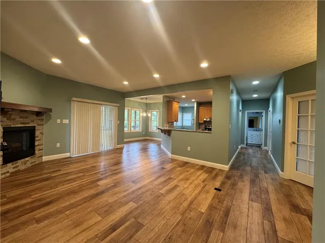 an empty room with wooden floor and fireplace