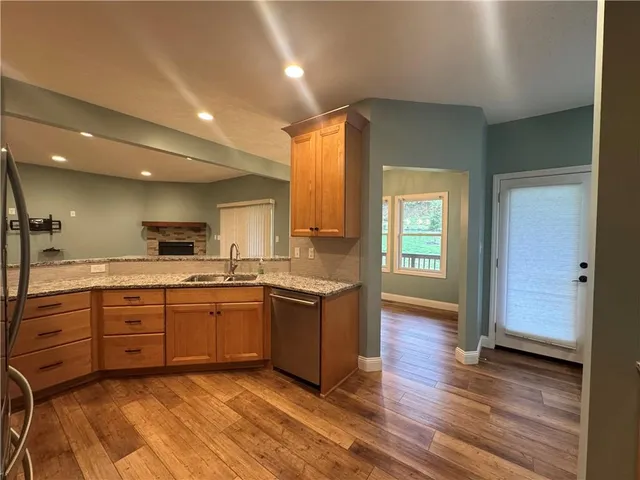 a large kitchen with wooden floors and stainless steel appliances
