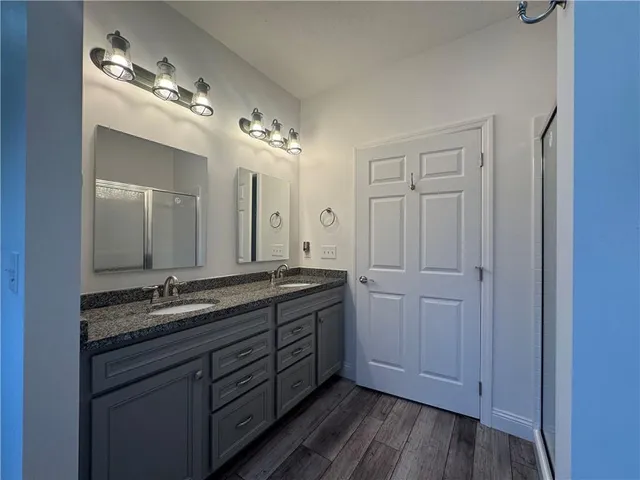 a spacious bathroom with a granite countertop sink a mirror and a vanity