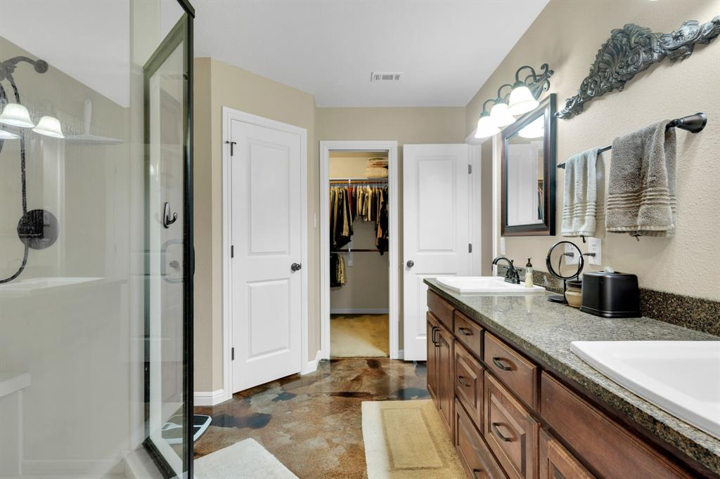 7731 Shady Lane Scurry, TX 75158 - Photo 26 of 40 Full bathroom featuring a shower stall, double vanity, and a spacious closet