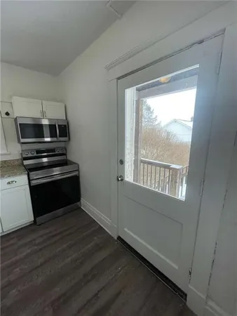 a kitchen with wooden floors and appliances