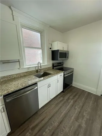 a kitchen with granite countertop a sink and a stove top oven