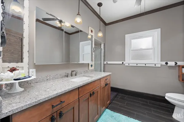 a bathroom with a granite countertop sink a toilet and a mirror