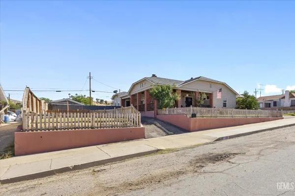 a front view of a house with a yard and potted plants