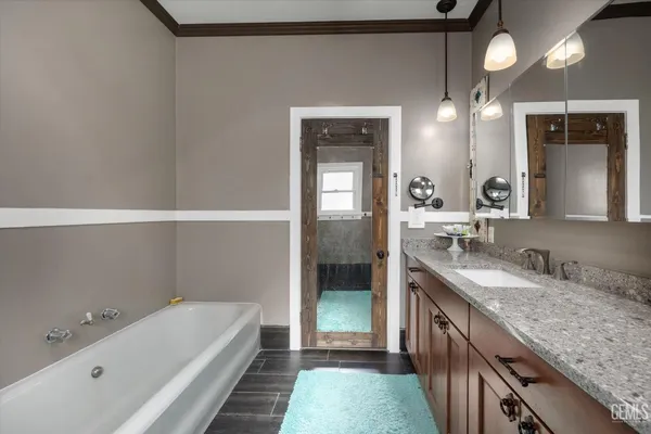 a bathroom with a granite countertop sink a large mirror and a bathtub