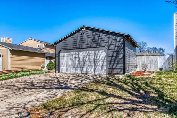 a view of a house with a small yard and wooden fence