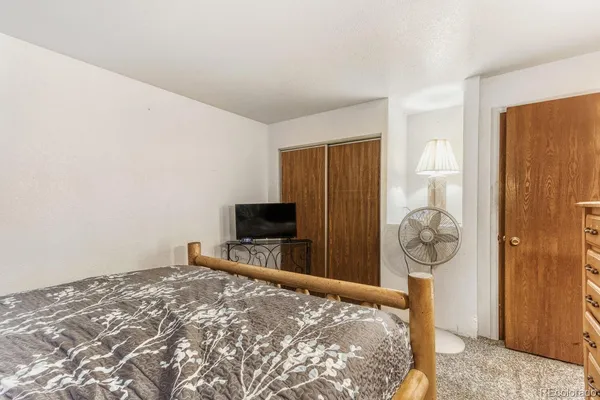 a bedroom with bed and wooden floor