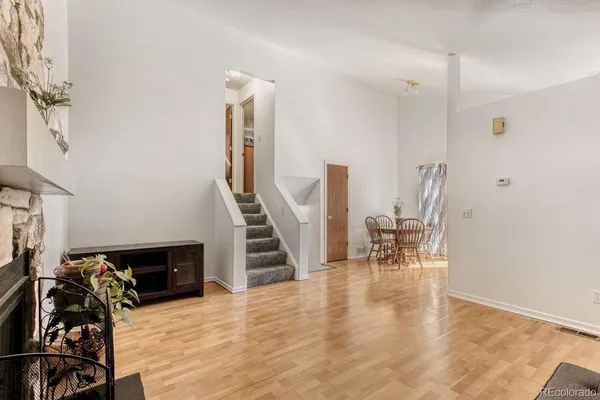 a view of a livingroom with wooden floor and stairs