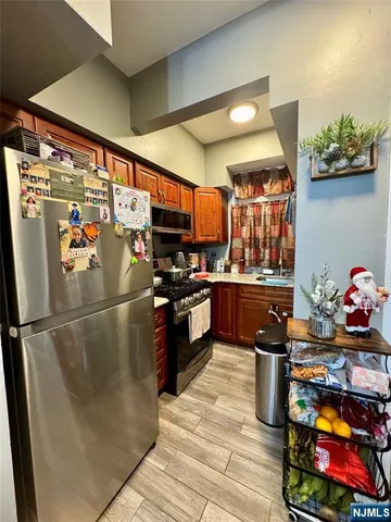 a kitchen with stainless steel appliances granite countertop a refrigerator a stove and a sink