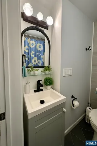 a bathroom with a sink and mirror with toilet
