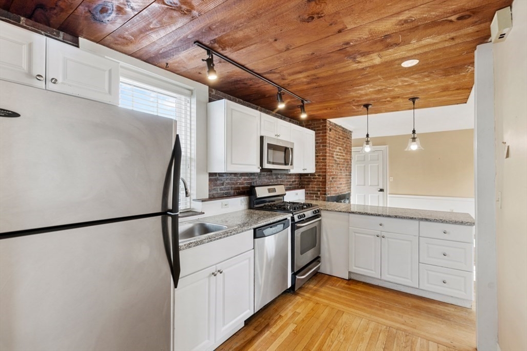 14 Mall Street, Unit B Salem, MA 01970 - Photo 11 of 30 a kitchen with stainless steel appliances granite countertop a refrigerator a stove and a sink
