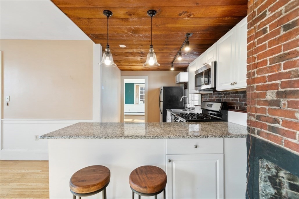14 Mall Street, Unit B Salem, MA 01970 - Photo 13 of 30 a kitchen with stainless steel appliances granite countertop a sink a stove cabinets and a wooden floor