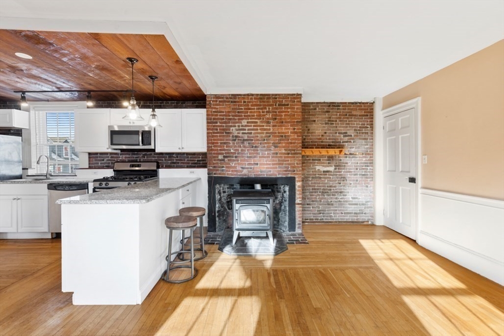14 Mall Street, Unit B Salem, MA 01970 - Photo 7 of 30 a kitchen with granite countertop a stove and cabinets