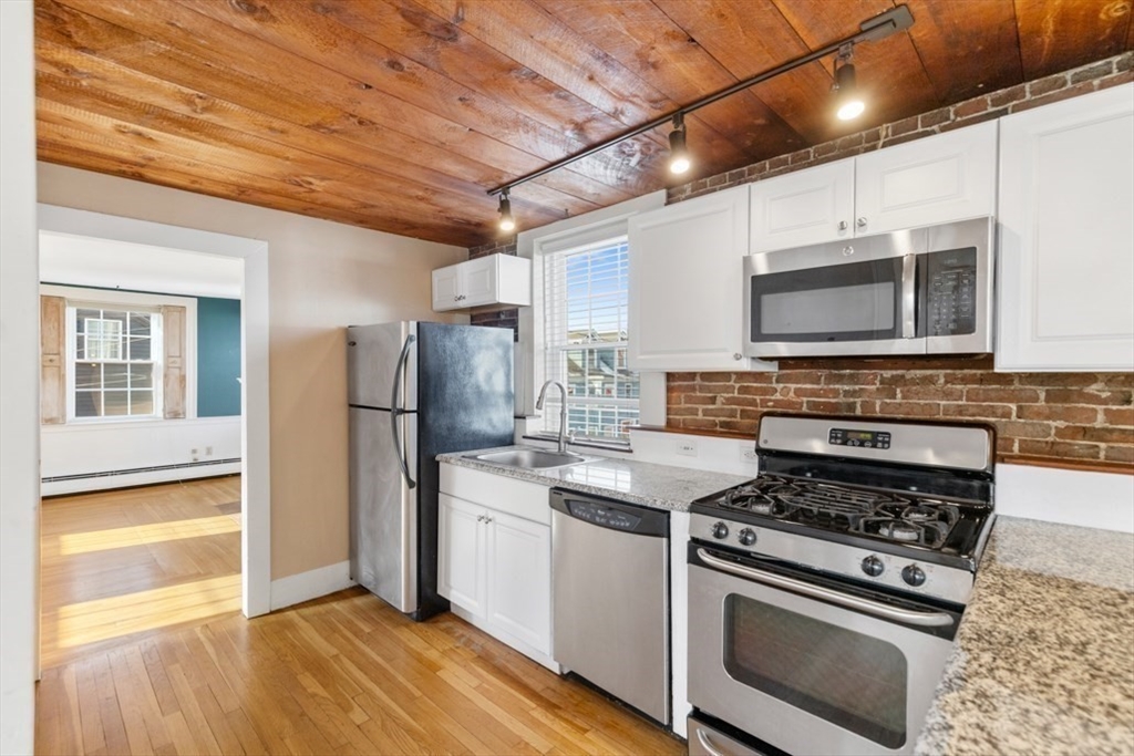 14 Mall Street, Unit B Salem, MA 01970 - Photo 10 of 30 a kitchen with stainless steel appliances a stove a microwave and a sink