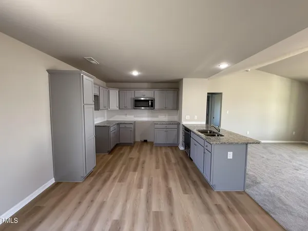 a large kitchen with a large counter top appliances and cabinets