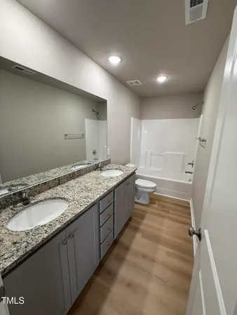 a bathroom with a granite countertop sink and a large mirror