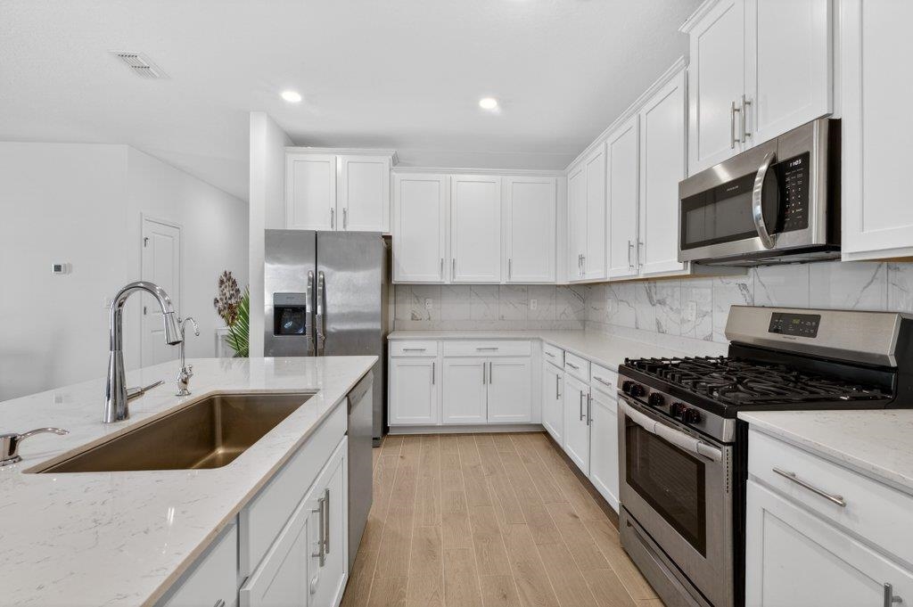 210 White Rabbit Run St. Augustine, FL 32092 - Photo 8 of 85 a kitchen with stainless steel appliances granite countertop a sink a stove a microwave and cabinets