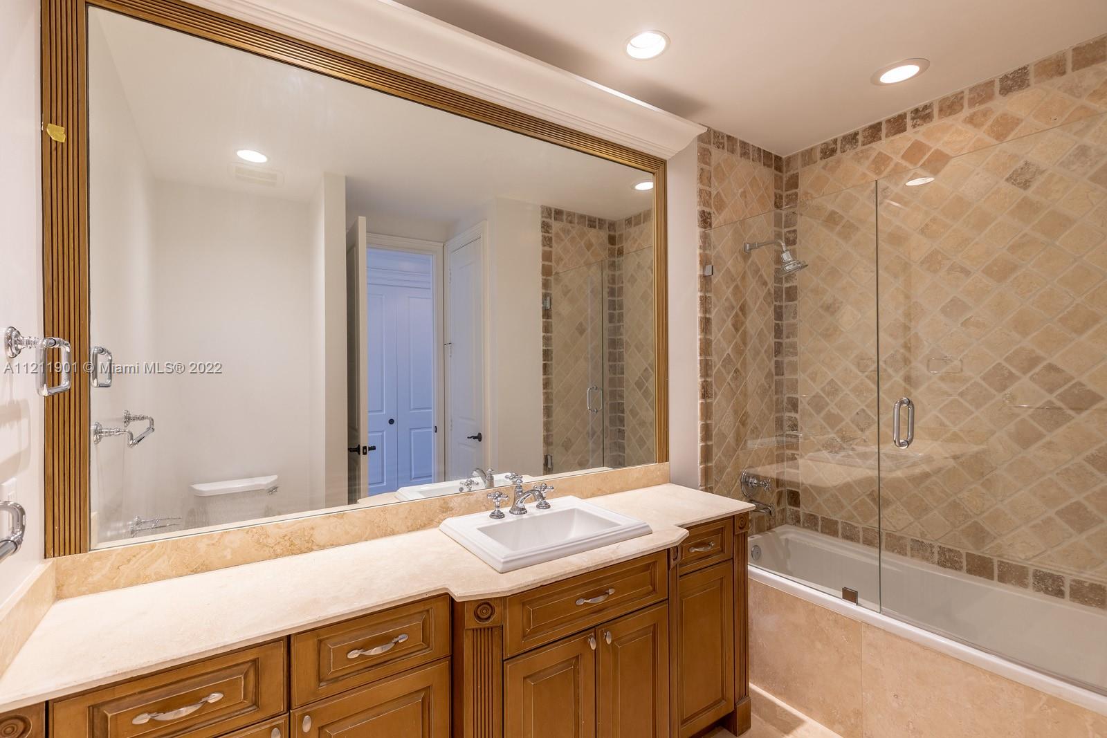 3471 Main Highway, Unit 928 Miami, FL 33133 - Photo 19 of 35 a bathroom with a granite countertop sink mirror and a bath tub