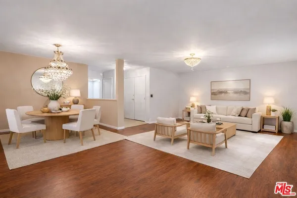 a living room with furniture chandelier and a table with wooden floor