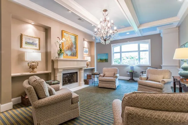 a living room with furniture a chandelier and a fireplace
