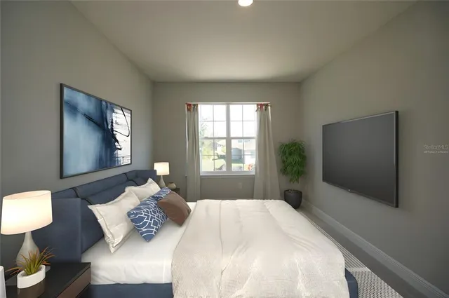 a bedroom with a bed and a flat tv screen on dresser