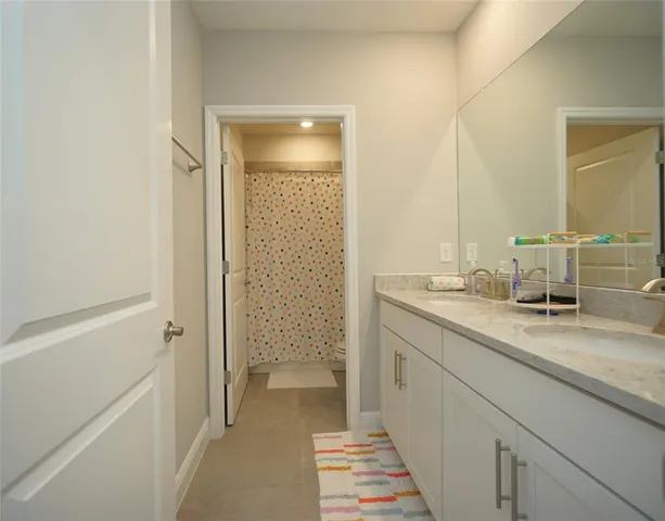 a en suite bathroom with a granite countertop sink and a mirror