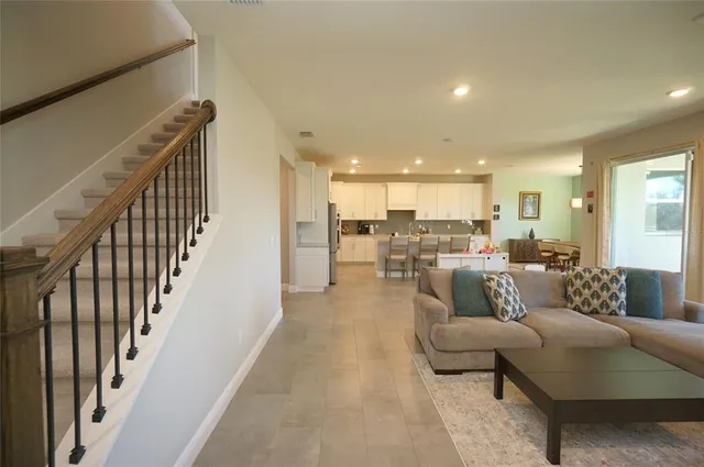 a living room with furniture and a view of kitchen